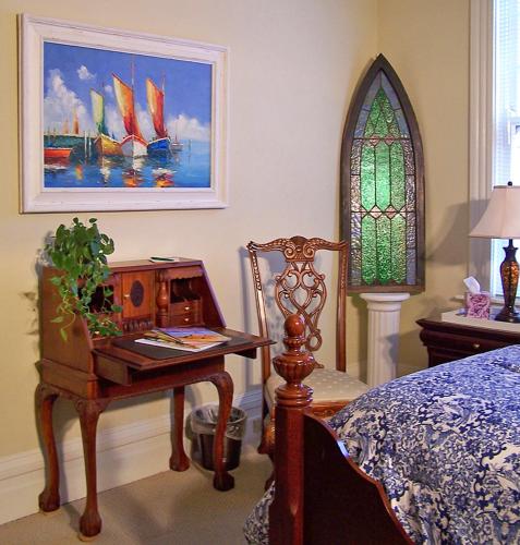 a bedroom with a desk and a table with a chair at Lyndon House Bed & Breakfast in Lexington