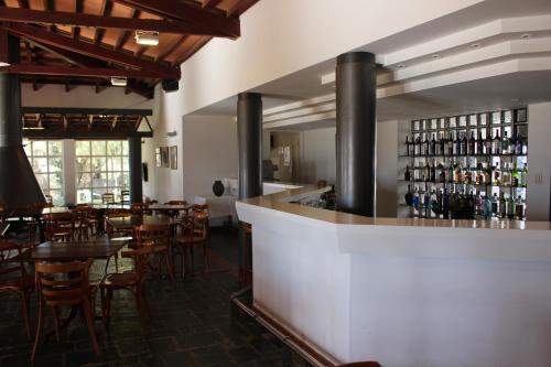 un restaurante con bar y algunas mesas y sillas en Hosteria Automovil Club Argentino Cachi en Cachí