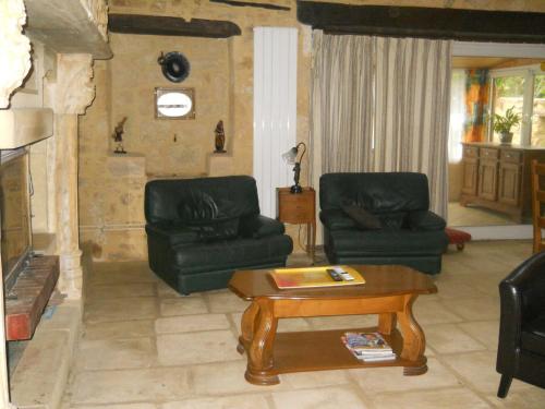 a living room with two chairs and a coffee table at Le Jaonnet in Nabirat