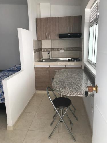 cocina con encimera, mesa y silla en Cavas AP, en Cali