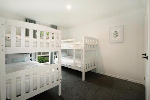 two white bunk beds in a white room at Sorrento Beach Escape in Sorrento