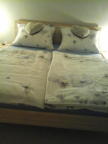 a bed with two blankets and pillows on it at Reitbergs Nest in Eugendorf