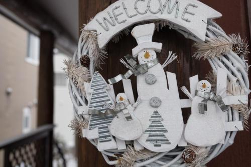 a wreath with snowmen and trees on a door at Sapporo Luxury Log House 5Brm max 18ppl 4 free parking in Sapporo