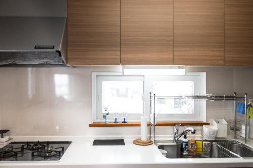 a kitchen with wooden cabinets and a sink and a window at Sapporo Luxury Log House 5Brm max 18ppl 4 free parking in Sapporo