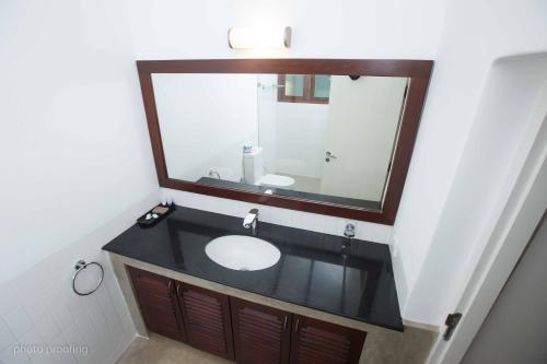 a bathroom with a sink and a large mirror at Jaffna Heritage Hotel in Jaffna
