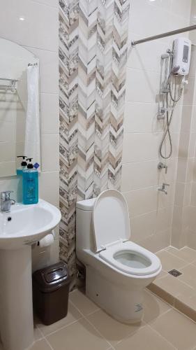 a bathroom with a toilet and a sink at Acrige Apartelle 2 pax Twin @ heart of Bogo City in Banban