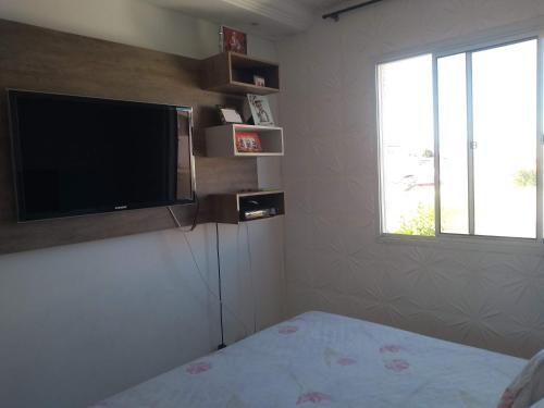 1 dormitorio con TV de pantalla plana y 1 cama en Barcelona, en Curitiba