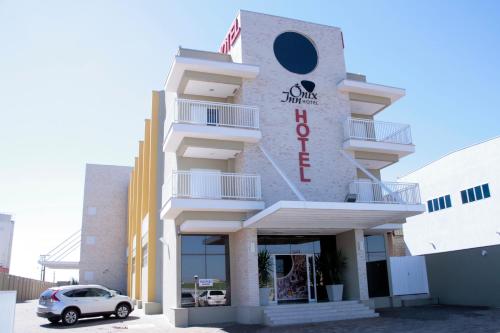 a building with a car parked in front of it at Ônix Inn Hotel Cravinhos in Cravinhos