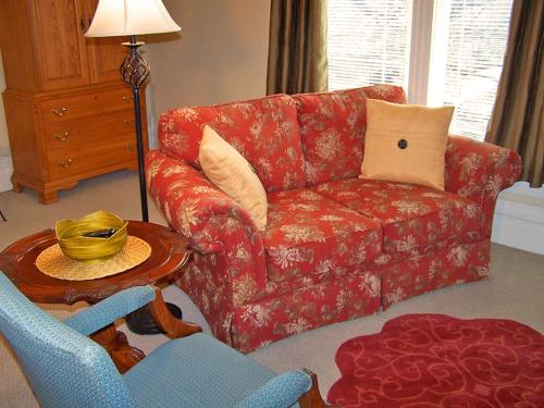 a living room with a red couch and a chair at Lyndon House Bed & Breakfast in Lexington