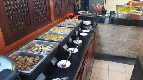 a buffet line with many trays of food at Sari Villa Ubud in Ubud