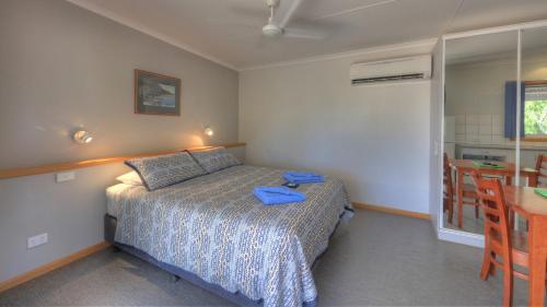 a bedroom with a bed and a table and a dining room at Discovery Parks - Katherine in Katherine