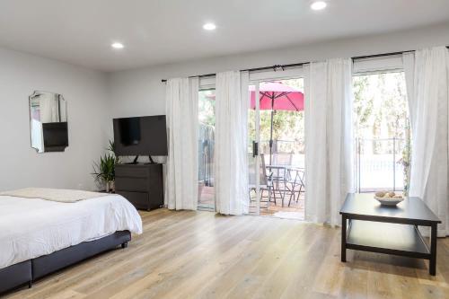 a bedroom with a bed and a television and a patio at Spacious Guest Studio with Private Entry in Los Angeles