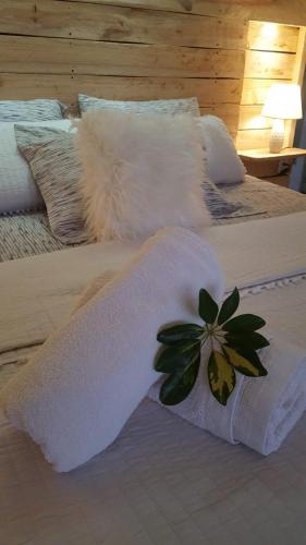 a bed with two white towels and a flower on it at Bidieen Inn Uruguay in Carrasco