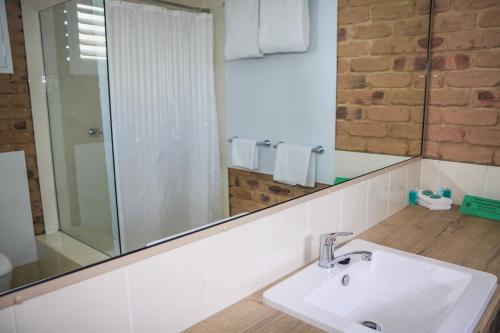 a bathroom with a sink and a mirror at The Club Motor Inn Chinchilla in Chinchilla