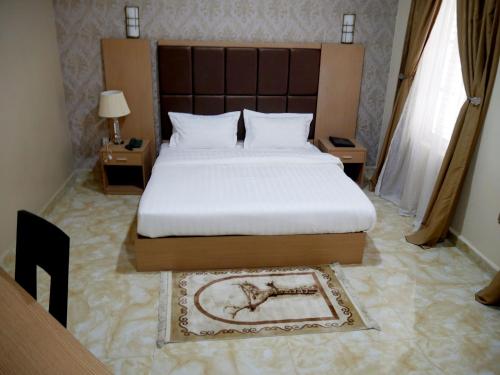 a bedroom with a large bed and two windows at Porto Golf Hotels in Kano