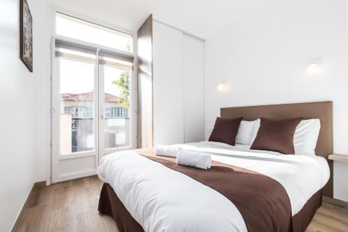 1 dormitorio con 2 camas y ventana grande en Sleep in Antibes City Port, en Antibes