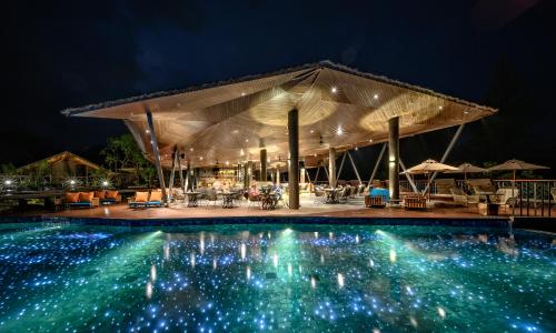 カオラックにあるKalima Resort and Villas Khao Lak - SHA EXTRA PLUSの夜間のパビリオン付きスイミングプール
