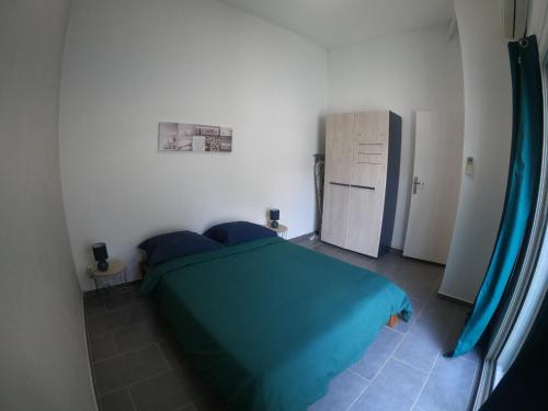 1 dormitorio con cama verde y nevera en F2 Crea Run en Saint-Pierre