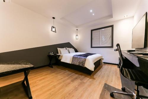 a bedroom with a bed and a television in a room at Seosan Aria Hotel in Seosan