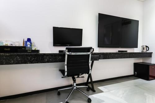 a desk with a chair and a television on a wall at Seosan Aria Hotel in Seosan