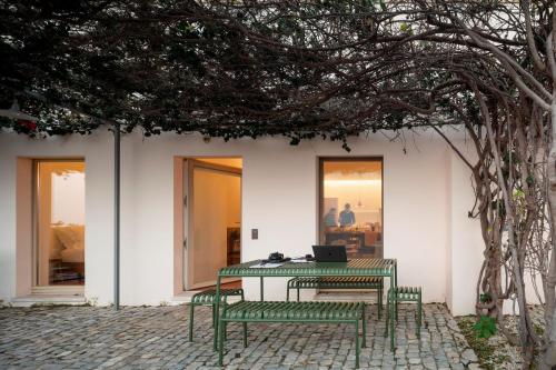 a table with a laptop on it next to two benches at Flattered to be in Algarve in Tavira