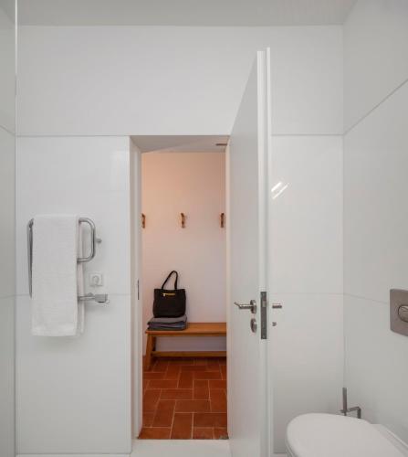a white bathroom with a toilet and a sink at Flattered to be in Algarve in Tavira