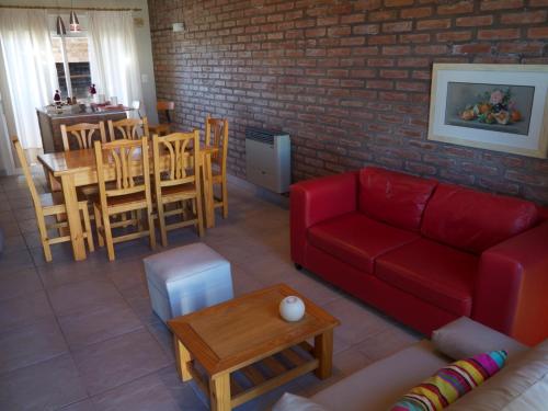 sala de estar con sofá rojo y mesa en Al Mare en Monte Hermoso
