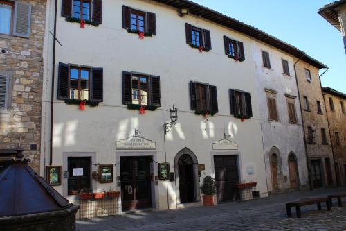 a white building with black shutters on a street at Le Terrazze Del Chianti b&b Residenza d'Epoca e di Charme in Tavarnelle in Val di Pesa