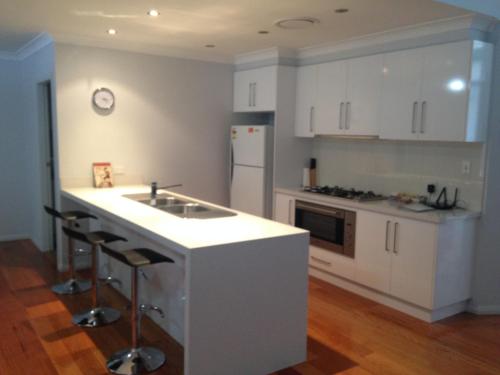 a kitchen with a sink, stove, and refrigerator at Griffith Prestige Apartments in Griffith