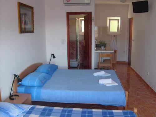 - une chambre avec un lit bleu et des serviettes dans l'établissement Apartments Bovan, à Herceg-Novi