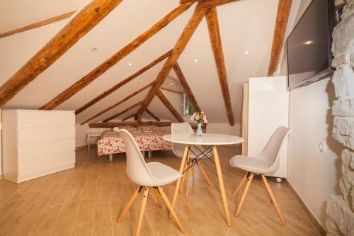 ein Zimmer mit einem Tisch und Stühlen im Dachgeschoss in der Unterkunft Apartment Zora & Natale in Pula