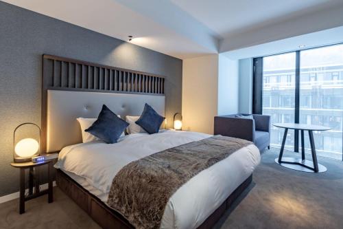 a bedroom with a large bed and a large window at The Vale Niseko in Kutchan