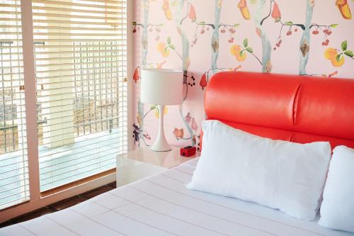 a bedroom with a red bed with a red headboard at Austin Motel in Austin