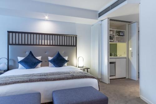 a bedroom with a large bed with blue pillows at The Vale Niseko in Kutchan