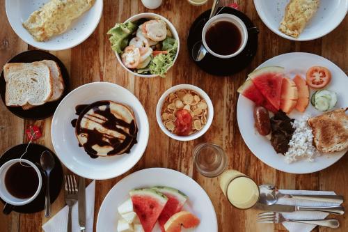 a wooden table topped with plates of breakfast foods at Panja Resort Palawan in Puerto Princesa City
