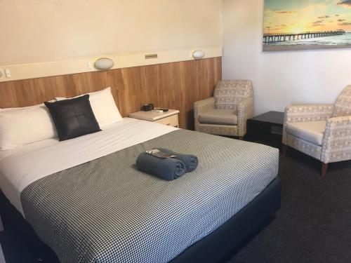 a hotel room with a bed with a bag on it at Wattle Tree Motel in Cootamundra