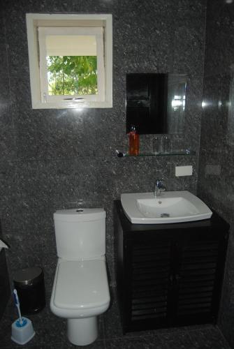 bagno con servizi igienici bianchi e lavandino di Panorama de Argao Boutique Resort ad Argao