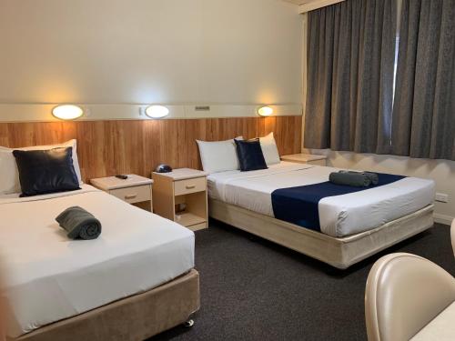 pokój hotelowy z 2 łóżkami i oknem w obiekcie Wattle Tree Motel w mieście Cootamundra