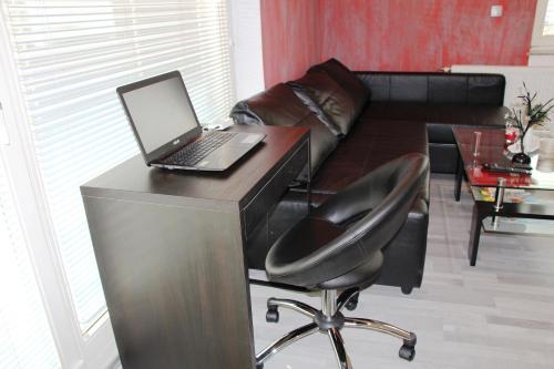a desk with a laptop and a chair in a living room at Apartment Lucija-Terme Šmarješke Toplice in Smarjeske Toplice