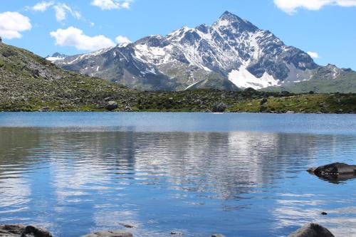 a mountain reflecting in a lake in the mountains at Hapimag Ferienwohnungen Andeer in Clugin