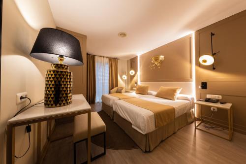 a hotel room with a bed and a lamp at Hotel Casablanca in Almuñécar