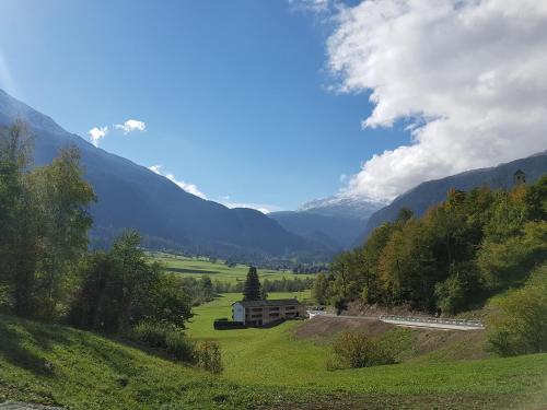 a train on a road in a valley with mountains at Hapimag Ferienwohnungen Andeer in Clugin