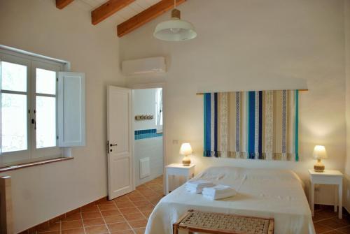 1 dormitorio con cama blanca y ventana en B&B Giallo Limone, en Teulada