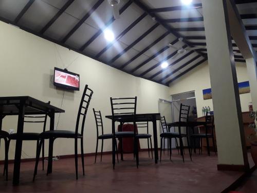 a room with chairs and a table and a television at Hansika Guest Inn in Buttala
