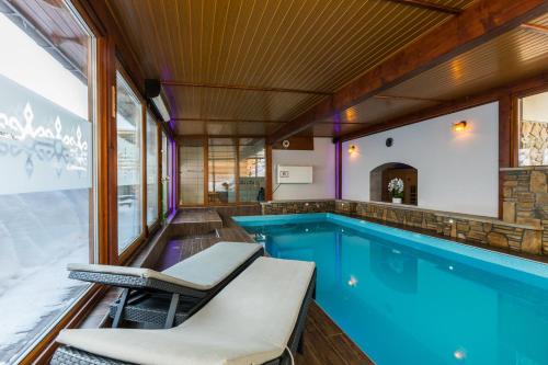 a swimming pool with chairs and a swimming pool at Willa Baciarka-basen, sauny i jacuzzi in Kościelisko