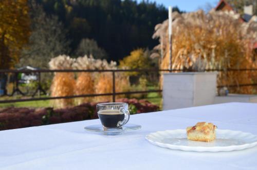 a cup of coffee and a piece of food on a table at Leonówka Bieszczady in Cisna