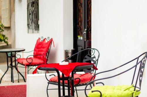 um pátio com cadeiras vermelhas e uma mesa em V Park Hotel em Tbilisi