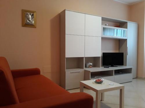 sala de estar con sofá, TV y mesa en Lux Appartamento en Busso