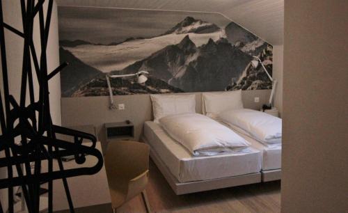 a bedroom with a bed with a painting on the wall at Hotel & Restaurant Forni in Airolo