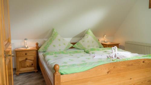 a bed with green and white sheets and pillows at Mehr -Nordseeurlaub in Butjadingen